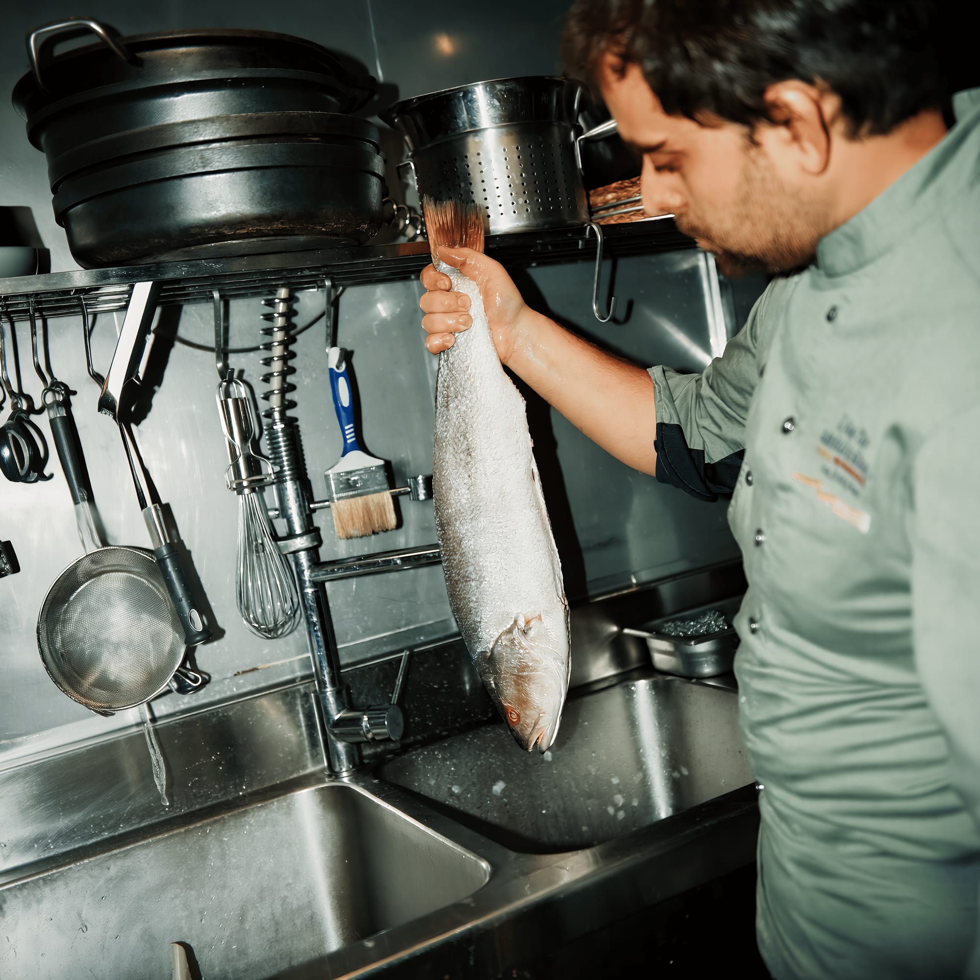 Alejandro limpiando pescado en cocina